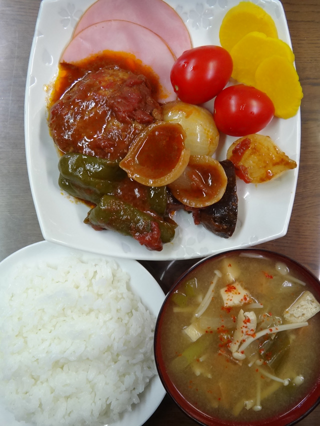 コメショウ　今日のお昼ごはん　ごはん　味噌汁　煮込みハンバーグ　トマト　たくあん