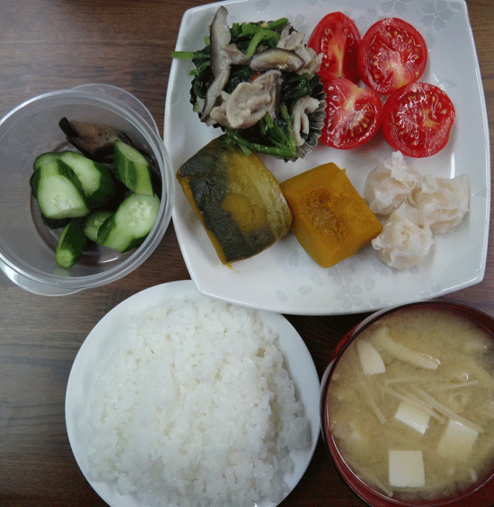 株式会社日食　ごはん　味噌汁　かぼちゃの煮物　豚肉と椎茸とほうれん草の炒め　えびシュウマイ　トマト　自家製ヌカ漬け