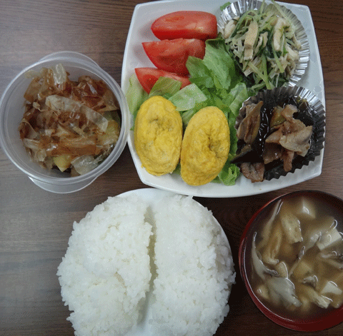 株式会社日食　今日のお昼ごはん　ごはん　味噌汁　豚肉とナスのオイスター炒め　水菜と油揚げのおひたし　5種の具の入ったミニオムレツ　トマト　サラダ　自家製ヌカ漬け