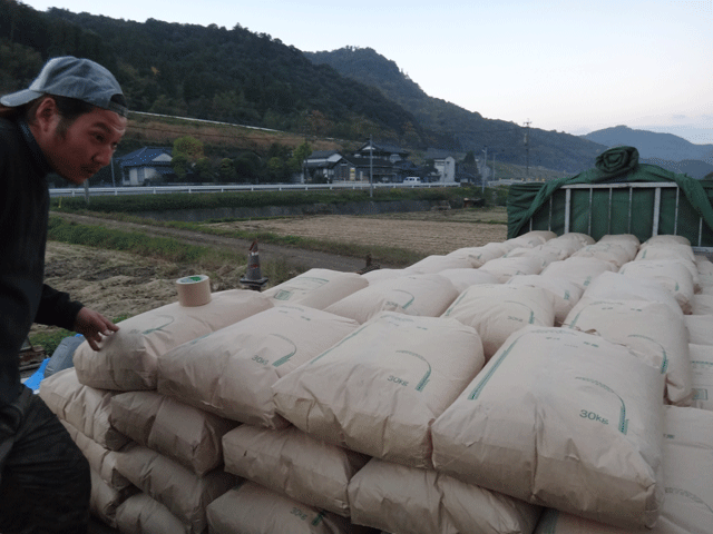 株式会社日食　生産農場ライスセンター　稲作屋　井上家　大分県中津市本耶馬渓町西谷　屑米　焼酎用　積み込み