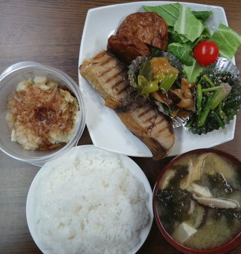 株式会社日食　今日のお昼ごはん　ごはん　味噌汁　富山県氷見の塩ブリ　かまぼこ　ほうれん草の胡麻和え　鶏肉・岩津ねぎ・椎茸の炒め物　サラダ　自家製漬物　白菜